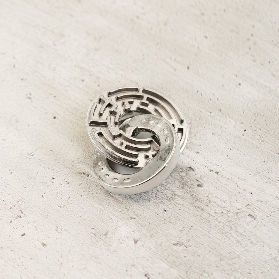 Vintage metal puzzle featuring two interlocking horseshoes and a central ring, crafted in durable steel with a rustic finish.