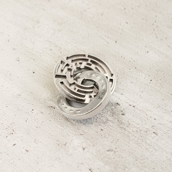 Vintage metal puzzle featuring two interlocking horseshoes and a central ring, crafted in durable steel with a rustic finish.