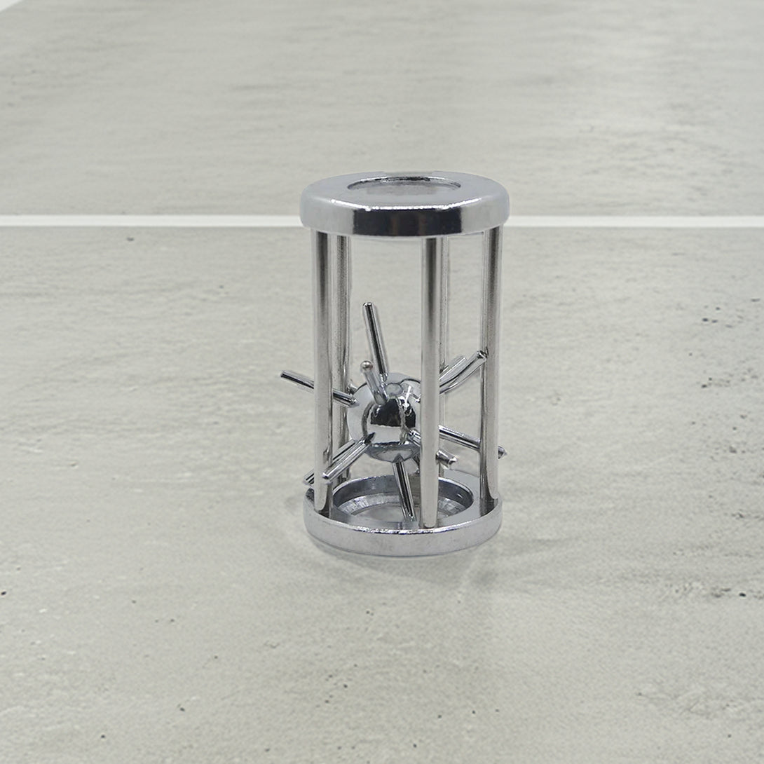Sleek metal puzzle featuring a captivating sphere trapped in a cylindrical cage of chrome rods, blending industrial style with brain-teasing fun.