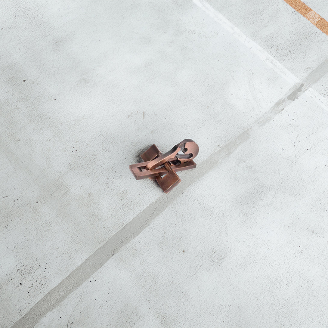 Elegant metal violin-shaped puzzle with a vintage copper finish, showcasing intricate interlocking pieces for a challenging brain teaser.