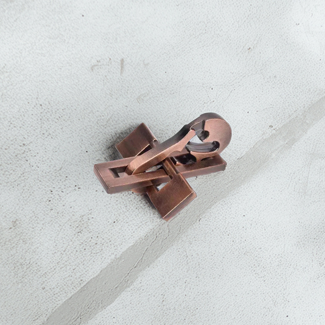 Elegant metal violin-shaped puzzle with a vintage copper finish, showcasing intricate interlocking pieces on display.