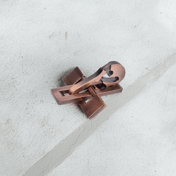Elegant metal violin-shaped puzzle with a vintage copper finish, showcasing intricate interlocking pieces on display.